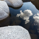 Clouds and granite boulders reflected in a high country stream