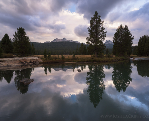 Unicorn Peak and Cathedral Peak reflected in a pool in the Tuolumne River during a stormy sunset