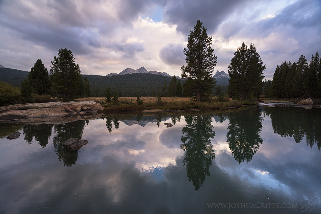 Unicorn Peak and Cathedral Peak reflected in a pool in the Tuolumne River during a stormy sunset